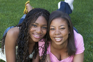 two girls laying in the grass
